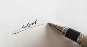 pen with signature and document in background
