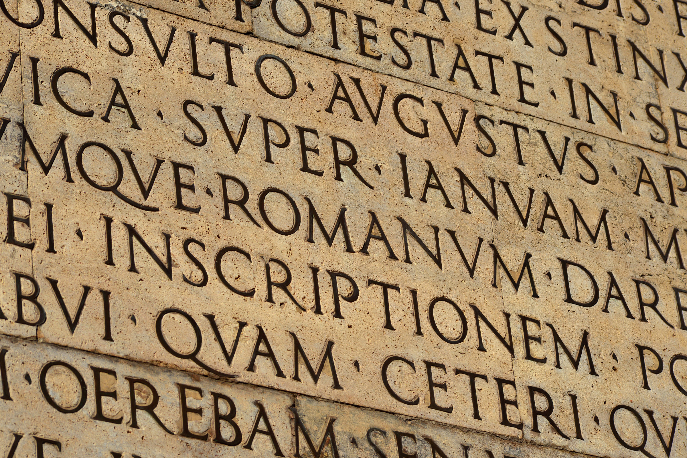 Latin ancient language and classical education. Inscription from Emperor Augustus famous Res Gestae (1st century AD), with the word Romanum in the center